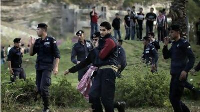 Jordanian policeman pushes away a pro government demonstrator who tried to reach a group of March 24 supporters.