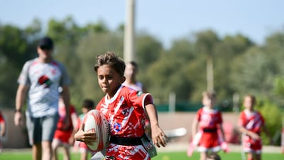 Young boys practice on the field at Dubai Police Academy, Dubai.