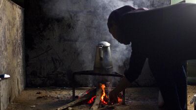 Khadeeja Adis, an employee of the family, makes a pot of fresh tea on the evening before Eid.
