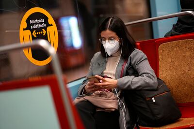 A woman wearing a face mask on a subway train in Lisbon. AP