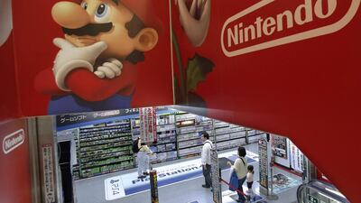 Shoppers walk under the logo of Nintendo and Super Mario characters at an electronics store in Tokyo. AP Photo/Shizuo Kambayashi