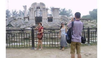 Chinese tourists pose at the Old Summer Palace in Beijing, a "patriotic education" site where Chinese learn about the damage inflicted by foreign powers.