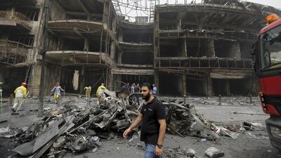 File photo from July 3, 2016 showing municipality workers clean the scene of a massive truck bomb attack in Karradah district of Baghdad, Iraq's deadliest single bombing in 13 years of war. Hadi Mizban/AP Photo