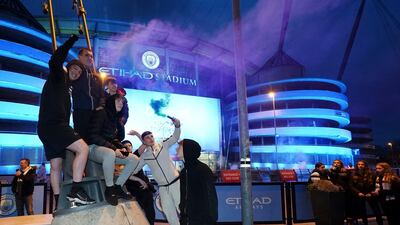 Manchester City supporters celebrate outside the Etihad Stadium. PA