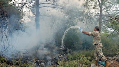 A Lebanese soldier tries to extinguish a fire in Mechref. EPA