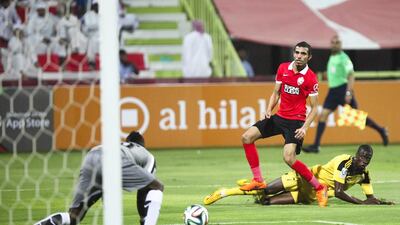 Kalba striker Papa Waigo, right, sees his shot saved by Al Ahli goalkeeper Majed Naser during their President's Cup round of 16 match at Rashid Stadium in Dubai on May 14, 2015. Lee Hoagland / The National