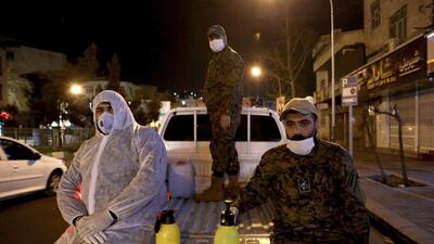 Members of Iran's Revolutionary Guard spray down streets and hospitals with disinfectants, March 4. AP