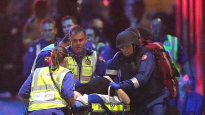 Emergency personnel wheel an injured hostage to an ambulance during a cafe siege in the central business district of Sydney, Australia on December 16, 2014. AP Photo/Rob Griffith