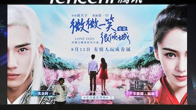 A visitor stands in front of an advert for Tencent in Fuzhou city, south-east China's Fujian province. Mobile games helped the tech juggernaut boost its earnings by 43 per cent.