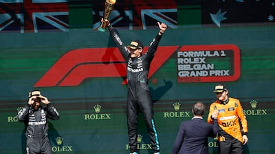 Mercedes driver George Russell celebrates on the podium with second-placed teammate Lewis Hamilton and third-placed Oscar Piastri of McLaren. AP