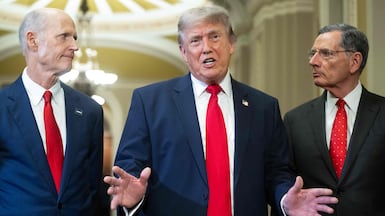 US President Donald Trump (C), alongside Senator Rick Scott (L), Republican from Florida, and Senator John Barrasso (R), Republican from Wyoming, speaks to the press after a lunch meeting with Senate Republicans at the US Capitol in Washington, DC, on June 24, 2026. President Trump said Wednesday he will refuse to sign a landmark housing bill, passed by Congress with broad bipartisan support, until lawmakers approve legislation that would overhaul American elections and restrict voter registration. (Photo by SAUL LOEB / AFP)