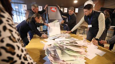 Members of a local electoral commission count ballots at a Vilnius polling station during the first round of Lithuania's presidential election. AFP