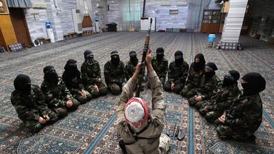Abu al-Taib, the leader of Ahbab Al-Mustafa Battalion, demonstrates to female members as he holds a gun during a military training in a mosque in Aleppo, Syria. Muzaffar Salman / Reuters