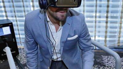 Tom Harding, Samsung's director of immersive products and VR 4D Experience, wears the company's redesigned VR headset as he rides a skateboard simulator in New York. Richard Drew / AP Photo