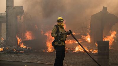 A firefighter works as a home burns during the 'Thomas Fire' which began overnight in Ventura, California. John Cetrino / EPA