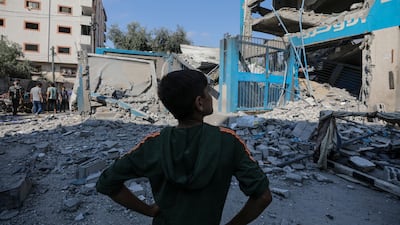 A Palestinian boy surveys a damaged UNRWA school after an Israeli air strike in Al Nuseirat refugee camp, central Gaza. EPA