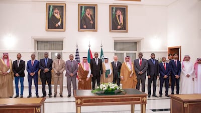 Saudi Foreign Minister Faisal bin Farhan, centre, flanked by representatives of the Sudanese army and the rival Paramilitary Rapid Support forces, after the signing of a ceasefire agreement in Jeddah. AFP