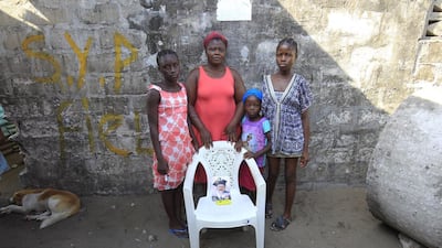 Rachael Fayia, centre, and her children Binta Jalloh, left, Fatmata Jalloh, right, Naomi Dee, second right, pose for a family portrait at their home in West Point, Monrovia, Liberia. The empty chair symbolises Rachael’s husband, who died of the Ebola virus during an outbreak of the disease in 2014. Ahmed Jallanzo / EPA