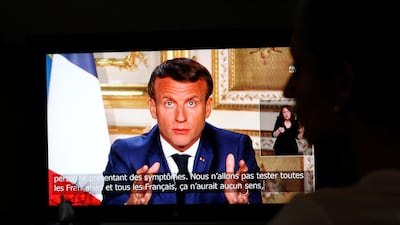 French President Emmanuel Macron is seen as he addresses the nation about the coronavirus disease (COVID-19) outbreak, on a television screen from confined people in Vertou, France, April 13, 2020. REUTERS/Stephane Mahe