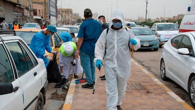 Iraqi municipality workers disinfect a street in the southern city of Nasiriyah in Dhi Qar province. AFP
