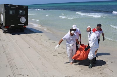 Libyan Red Crescent workers carry the body of a drowned migrant in Zuwara in 2021. AP