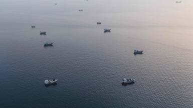 This aerial photograph shows boats anchored off Oman’s northern Musandam Peninsula near the Strait of Hormuz on June 27, 2026. Iran launched attacks on US sites in the Gulf in response to American strikes on the country, state media said on June 27, after Washington accused Tehran of attacking one of its cargo ships in the Strait of Hormuz. The trading of fire raised questions about efforts to keep the crucial waterway open while Washington and Tehran negotiate a final settlement to a war that began on February 28 with US and Israeli strikes on Iran. (Photo by AFP) /