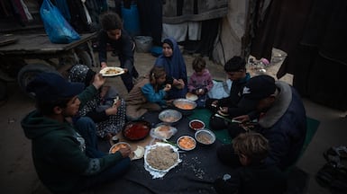 A displaced Palestinian family gathers for iftar outside their tent in Gaza city. EPA