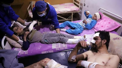 Doctors tend to ten-year-old Omar who was injured in an air strike that killed several members of his family on their home in Otaybah, in Syria's rebel-held enclave of Eastern Ghouta, as his father and seven-year-old sister, Manar, watch on at a make-shift hospital on February 25, 2018. Amer Almohibany / AFP