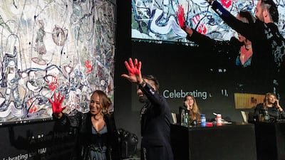 Marjorie Harvey shows off her palm after placing a finishing hand print on one of Sacha Jafri's art works during an auction to raise money for the 100 Million Meals campaign in Dubai. Antonie Robertson / The National