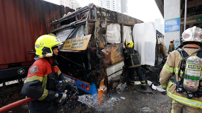 Thai rescue workers extinguish a fire on a public bus. EPA