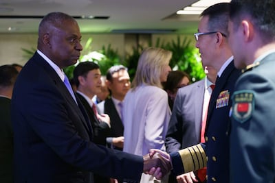 US Secretary of Defence Lloyd Austin shakes hands with Chinese Defence Minister Dong Jun on the sidelines of the Shangri-La Dialogue in Singapore this week. Bloomberg