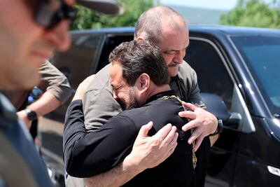 The head of Dagestan Republic of Russia, Sergei Melikov, centre, embraces and comforts a priest as he visits the Orthodox Church of the Intercession of the Blessed Virgin Mary in Derbent after the attack. AP