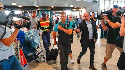 Australian cricket player David Warner, centre, departs from Cape Town International airport. Nic Bothma / EPA