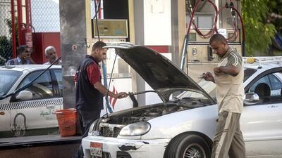 A Egyptian worker fills the car of a client at a petrol station in Cairo as the government drastically raised fuel prices to tackle a bloated subsidy system. Mahmoud Khaled / AFP