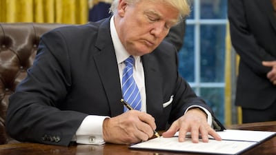 Donald Trump signs an executive order to withdraw from the Trans-Pacific Partnership agreement on his first Monday in the Oval Office. Ron Sachs via Bloomberg