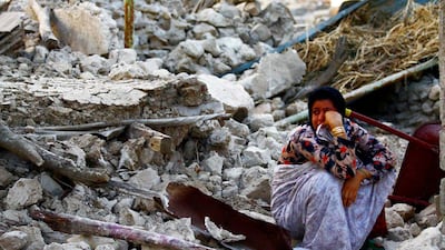 epa03655877 An Iranian woman sits on the rubble in the Shonbeh Twon in Bushehr province in southern Iran, 09 April 2013. The quakes, ranging in magnitude 6.3 on the Richter Scale, shook the Shanbeh town and other communities in Bushehr province in southern Iran on 09 April 2013. At least 37 people were killed in a 6.3-magnitude earthquake near Bushehr in southern Iran, state television reported. EPA/MOHAMAD FATEMI *** Local Caption *** 03655877.jpg