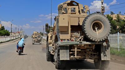 Vehicles from the US-led coalition battling ISIS patrol the town of Rmelane in Syria's Hasakeh province on June 5, 2018. Delil Souleiman / AFP