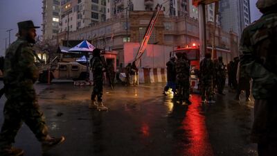 Taliban fighters stand guard at the scene of the bomb blast. EPA