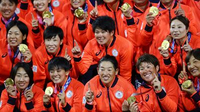 Japan players pose with their softball gold medals.