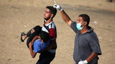 A wounded Palestinian boy is evacuated during clashes with Israeli troops at a protest demanding the right to return to their homeland at the border fence between Israel and Gaza, in the southern Gaza Strip August 24, 2018. REUTERS/Ibraheem Abu Mustafa