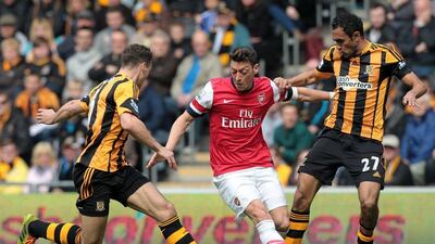 Hull City's Egyptian midfielder Ahmed Elmohamady, right, and English defender James Chester challenge Arsenal's German midfielder Mesut Ozil, centre, during their Premier League contest on Sunday. Lindsey Parnaby / AFP / April 20, 2014
