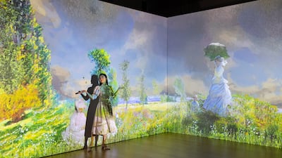 A woman stands next to paintings by french impressionist Claude Monet displayed on an Immersive Wall during a preview entitled 'En Voyage with Claude Monet. The First-ever Immersive Experience of Monet in Hong Kong' in Hong Kong, China, 15 September 2022. The immersive experience featuring works from the impressionist painter will bring more than 300 paintings to life through an application of light, sound and a 360 degrees animation when it opens on 27 October 2022. EPA / JEROME FAVRE