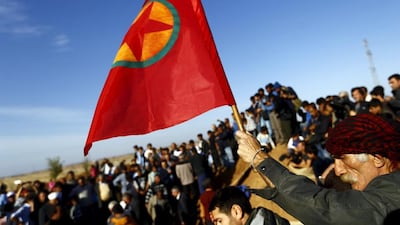 A Turkish Kurd holds a flag during the funeral of three Kurdish fighters killed during clashes in Kobane (REUTERS/Kai Pfaffenbach)