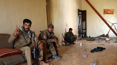A Syrian Democratic Forces fighter flashes a victory sign as he sits with his fellow fighters inside a room in Al Mishlab district at Raqqa's southeastern outskirts, Syria June 7, 2017. Rodi Said/Reuters
