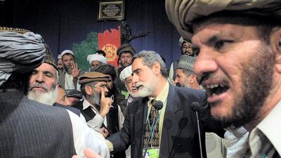 Afghan delegates discuss with each other the formation of a new legislative body during the Loya Jirga grand assembly in Kabul, 16 June 2002. Afghanistan's Loya Jirga traditional gathering was in uproar, as debate raged over the thorny issue of the make-up of the nation's assembly . AFP PHOTO-POOL/ Sergei GRITS (Photo by SERGEI GRITS / POOL / AFP)