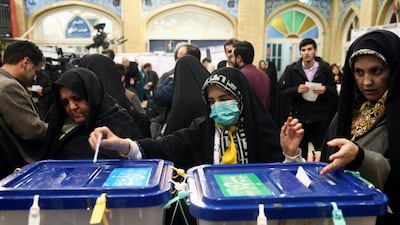 A woman wears a face mask as she casts her vote during parliamentary elections at a polling station in Tehran. REUTERS