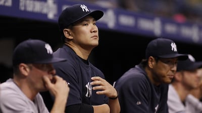With their large investment, the New York Yankees would prefer Masahiro Tanaka, second from left, be pitching games not watching them. The Japanese star, recovering from a partial tear in his throwing elbow, has thrown bullpen sessions, and the Yankees are wary of rushing him back to action too soon. Brian Blanco / AFP