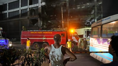 An onlooker sees firefighters continue to fight the blaze. AP
