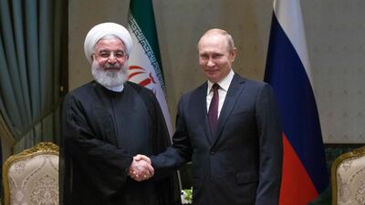 Iran's President Hassan Rouhani, left, and Russia's President Vladimir Putin shake hands before a meeting in Ankara, Turkey, Wednesday, April 4, 2018. Tolga Bozoglu /Pool Photo via AP