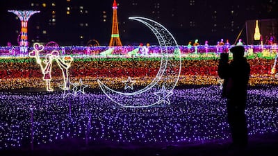 A man takes pictures of illuminated decorations at a lighting display in Handan, Hebei province, China. AFP